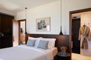 a bedroom with a large bed and a bathroom at Aernia Suites & Art in Akrotiri