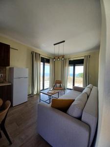 een woonkamer met een bank en een keuken bij Pezoulia Cottages in Samothráki