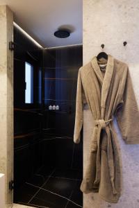 a robe hanging in a bathroom with a shower at Aernia Suites & Art in Akrotiri