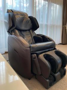 a leather reclining chair sitting next to a table at Condominium Panoramique Motomachi in Hakodate