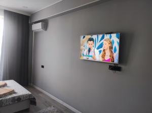 Un televisor de pantalla plana colgado en la pared de una habitación. en Heaven 10, en Almaty