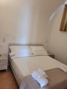 a bedroom with a bed with two towels on it at Trullo il Gelso in San Michele Salentino