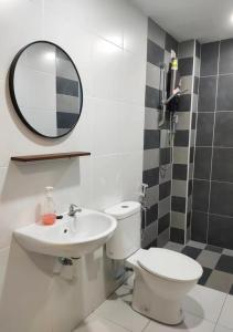 W łazience znajduje się toaleta, umywalka i lustro. w obiekcie Ipoh Homestay - Manhattan Condominium with Water Park & Leisure Facilities w mieście Ipoh