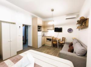 a living room with a couch and a kitchen at FLEMING Loft PARKING Tourist Córdoba in Córdoba