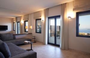 a living room with a couch and a large window at Aernia Suites & Art in Akrotiri