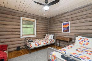 Dormitorio en cabaña de madera con 2 camas y ventana en Bald Eagle en Kingston Springs