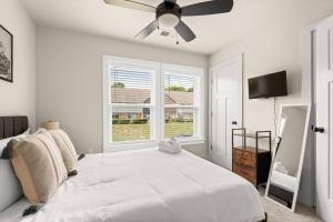 ナッシュビルにあるNashville Getawayの白いベッドルーム(ベッド1台、天井ファン付)