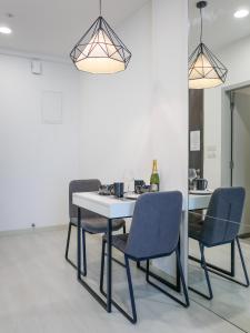 a dining room with a white table and blue chairs at Penang Straits Garden Condominium Georgetown in George Town