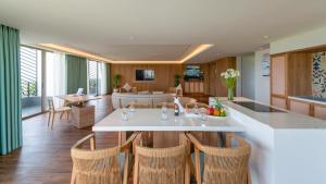een keuken en een woonkamer met een tafel en stoelen bij Bellerive Hoi An Hotel and Spa in Hội An