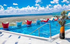 a swimming pool with red and blue chairs and the beach at Emara Ole-Sereni-Nairobi Park View in Nairobi