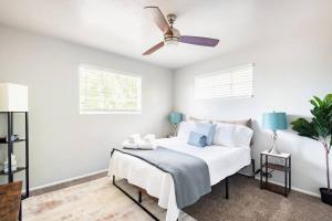 1 dormitorio blanco con 1 cama y ventilador de techo en Cute Midcentury Modern, en Phoenix