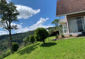 a house on a hill with a green yard at Cuckoos Nest in Vagamon