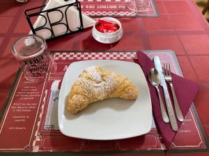 a white plate with a piece of food on a table at Albergo Mendolia in Milazzo