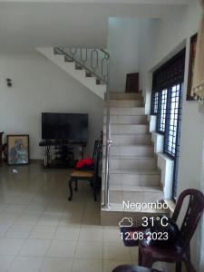 een woonkamer met een trap en een tv bij Randi Homestay in Negombo