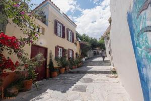 an alley with potted plants on the side of a building at At the foot of Acropolis. in Athens