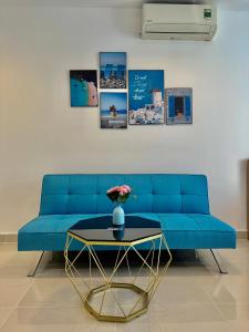 胡志明市的住宿－Teddy Apartment at Sky Center Luxury，客厅配有一张蓝色的沙发,配有一张桌子