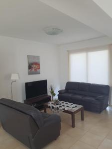 uma sala de estar com um sofá e uma mesa de centro em Yama's Villa - Polyxenia luxury, protaras, cyprus em Protaras
