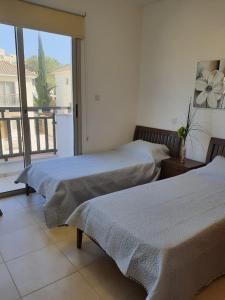 two beds in a room with a balcony at Yama's Villa - Polyxenia luxury, protaras, cyprus in Protaras