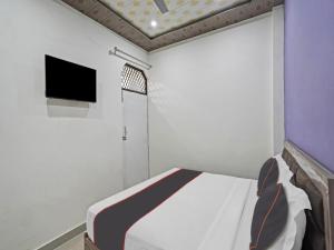 a small room with a bed and a tv at Collection O 81112 Hotel Joyous in Ghaziabad