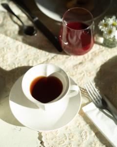 una tazza di caffè e un bicchiere di vino rosso di Casa Saba ospitalità con vista a Rustico