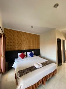 a bedroom with a large bed with towels on it at Jesens Inn II in Kuta