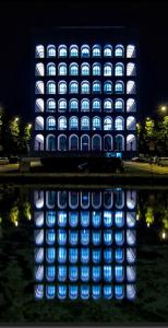 un edificio illuminato con luci blu e bianche di EUR suite BEETHOVEN a Roma