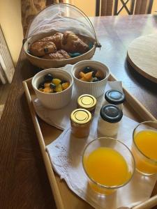 ein Tablett mit Essen auf einem Tisch und Orangensaft in der Unterkunft Maple Tree Chambre d'hôtes in Darnac