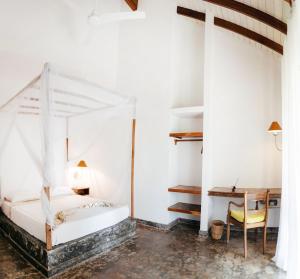 a bedroom with a white bed and a desk at Amuura Beach Villa in Beruwala