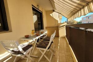 un patio avec une table et des chaises sur un balcon dans l'établissement Appart le Lavandou (le st James) 2 étoiles, au Lavandou