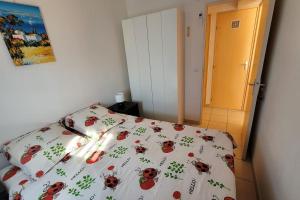 une chambre avec un lit avec un couvre-lit avec des coccinelles dessus dans l'établissement Appart le Lavandou (le st James) 2 étoiles, au Lavandou