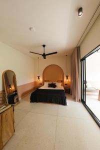 1 dormitorio con 1 cama y ventilador de techo en Black Honey, en Ahangama