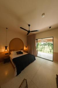 una camera con letto e ventilatore a soffitto di Black Honey ad Ahangama