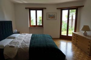 um quarto com uma cama, uma cómoda e janelas em Casa Verbanella em Minusio