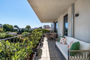 een balkon met een bank en een aantal planten bij BONFIM LIVING - Great location, al fresco dining and free private parking in Porto