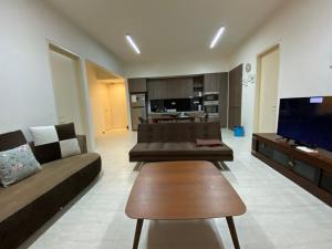 - un salon avec deux canapés et une télévision dans l'établissement By The Sea @ Cozy Beachfront Home, à Batu Ferringhi