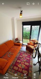 a living room with an orange couch and a rug at Albatros in Büyükçekmece