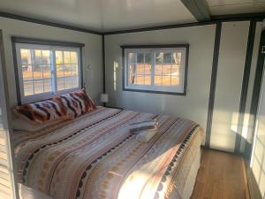 a bedroom with a large bed with two windows at Blue Sapphire Motor Inn in Glen Innes