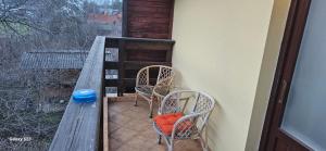 uma varanda com 2 cadeiras, uma mesa e uma janela em Vila Ralf em Cornu de Jos