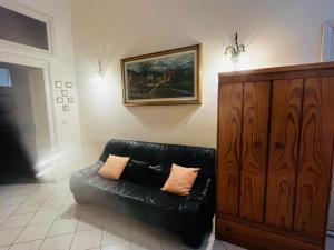 a black leather couch in a living room with a painting at Casa in centro a Giarre in Giarre