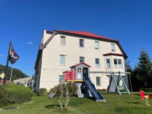 ein Gebäude mit einem Spielplatz vor einem Haus in der Unterkunft Wisełka PERŁA Bałtyku in Wisełka