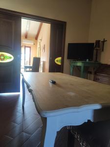 un tavolo in legno in un soggiorno con TV di Magnolia House a Taurianova