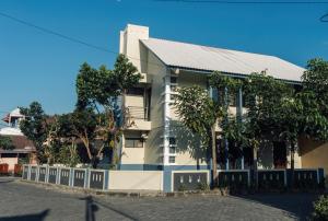 un edificio bianco con alberi di fronte di Twin House a Kaliurang