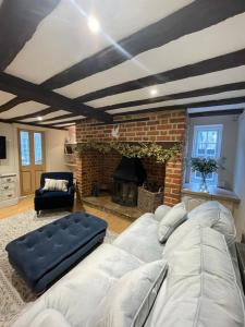 uma sala de estar com um sofá e uma lareira em Historic Cambridgeshire Cottage em Godmanchester