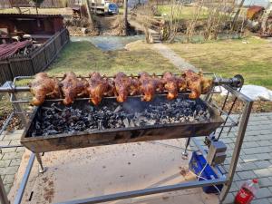 una parrilla con pollos y carne cocinando en ella en Gyopár Vendégház en Satu Mare