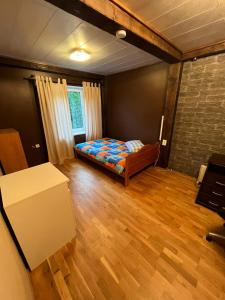 um quarto com uma cama e piso em madeira em Soo Rendimaja em Võru