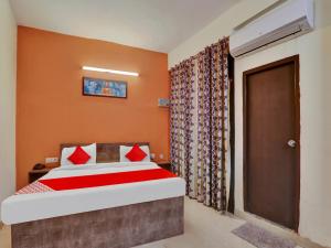 a bedroom with a bed with orange walls and a door at OYO Flagship Hotel SMS in Lucknow
