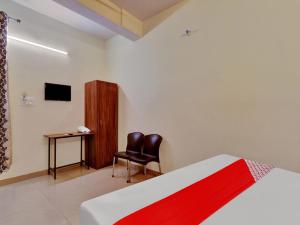 a bedroom with a bed and a chair and a desk at OYO Flagship Hotel SMS in Lucknow