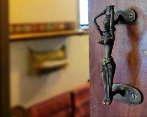 a metal door handle on a wooden door at Singharaja Garden AGRO ECO Lodge in Pelawatta