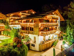 una casa con luces encendidas por la noche en Hotel Montchalet en Ortisei