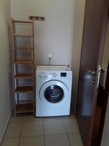una lavatrice e asciugatrice in una piccola stanza di G3 sea view appartment a Igoumenítsa